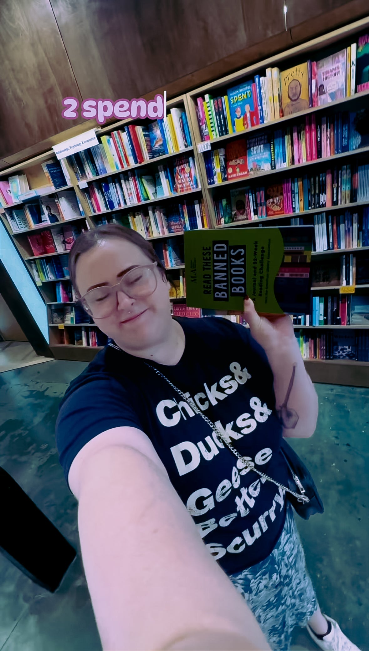 Person holding a book titled 'Banned Books' in a bookstore setting